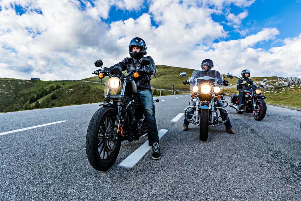 A line of motorcycles stretches out on the highway, their riders enjoying the open road.