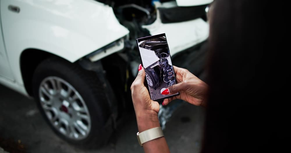 Person Taking Picture Of Damaged Car On Mobile Phone