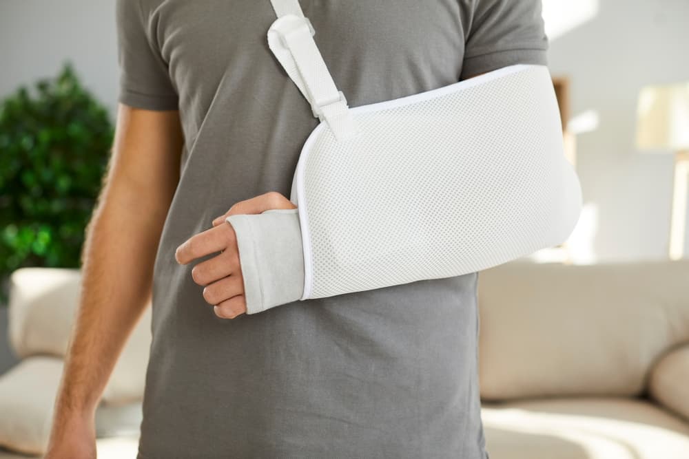 Close up of sling on broken arm of man he needs to wear during rehabilitation period. 