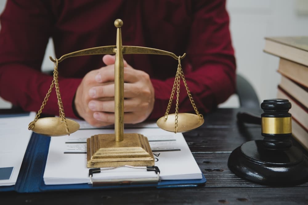 A male lawyer meticulously reviews legal documents, ensuring accuracy and compliance for an upcoming court case.
