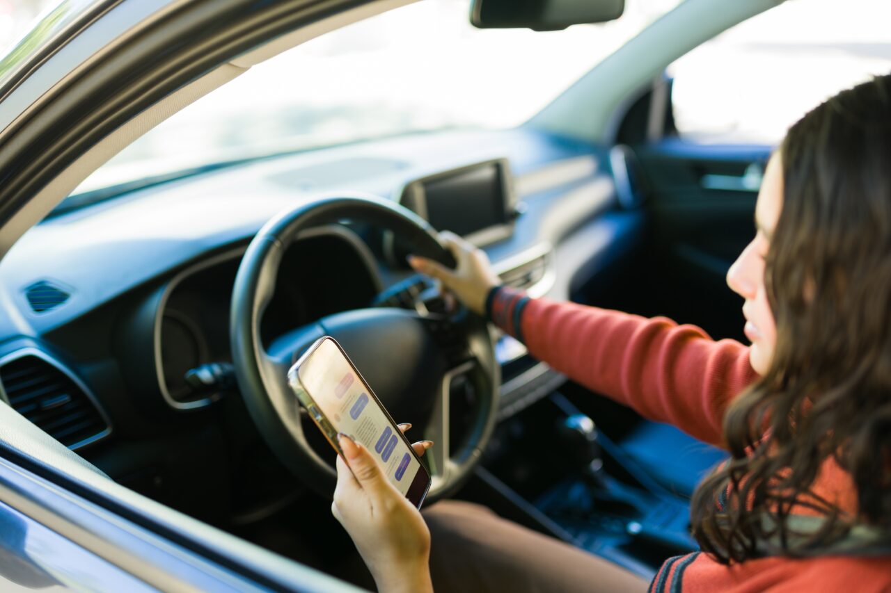 Young woman texting on phone while driving, distracted driving risk. Young woman texting on phone while driving, distracted driving risk.