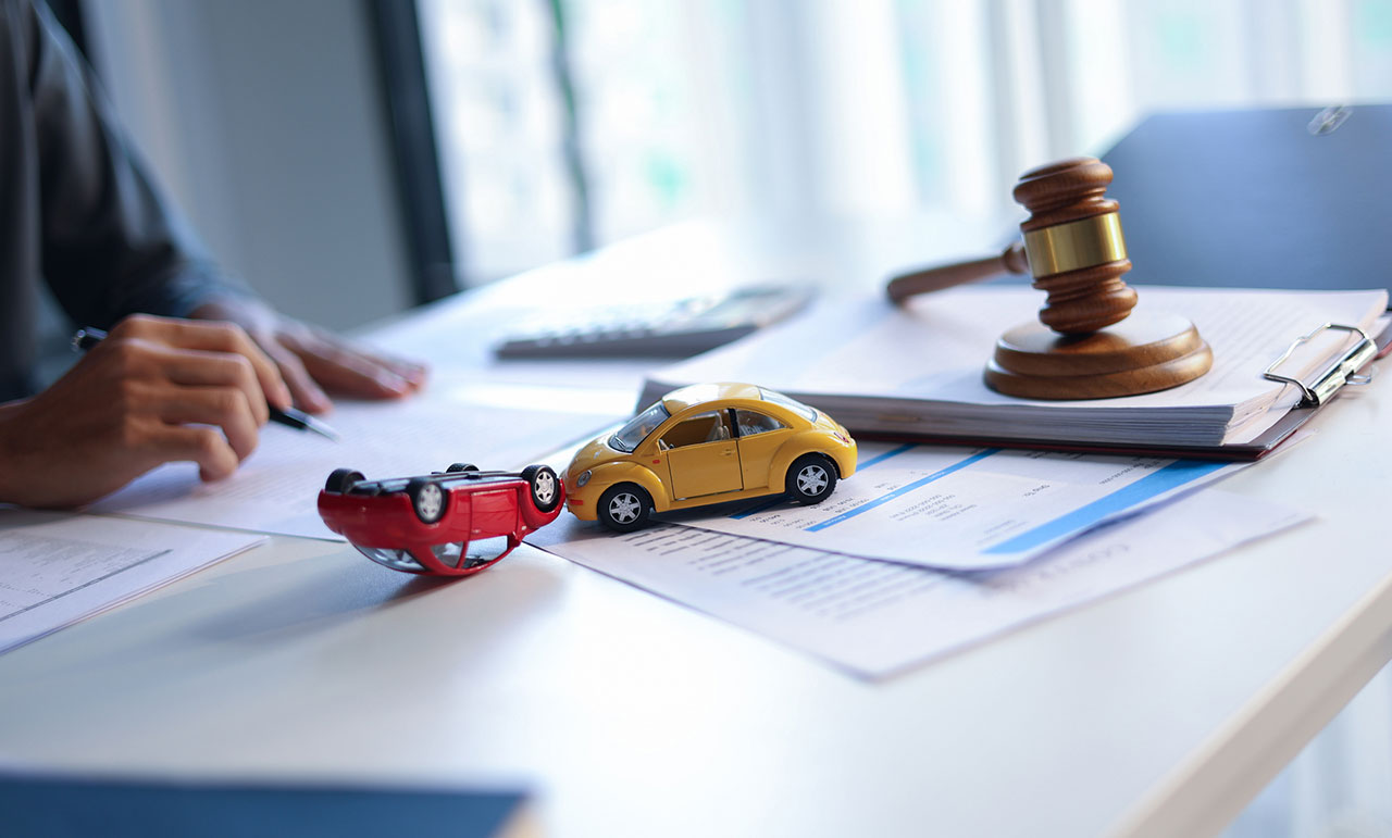Judge’s gavel beside a car model on a desk, concept image representing court approval and friendly suit requirements for a minor’s settlement