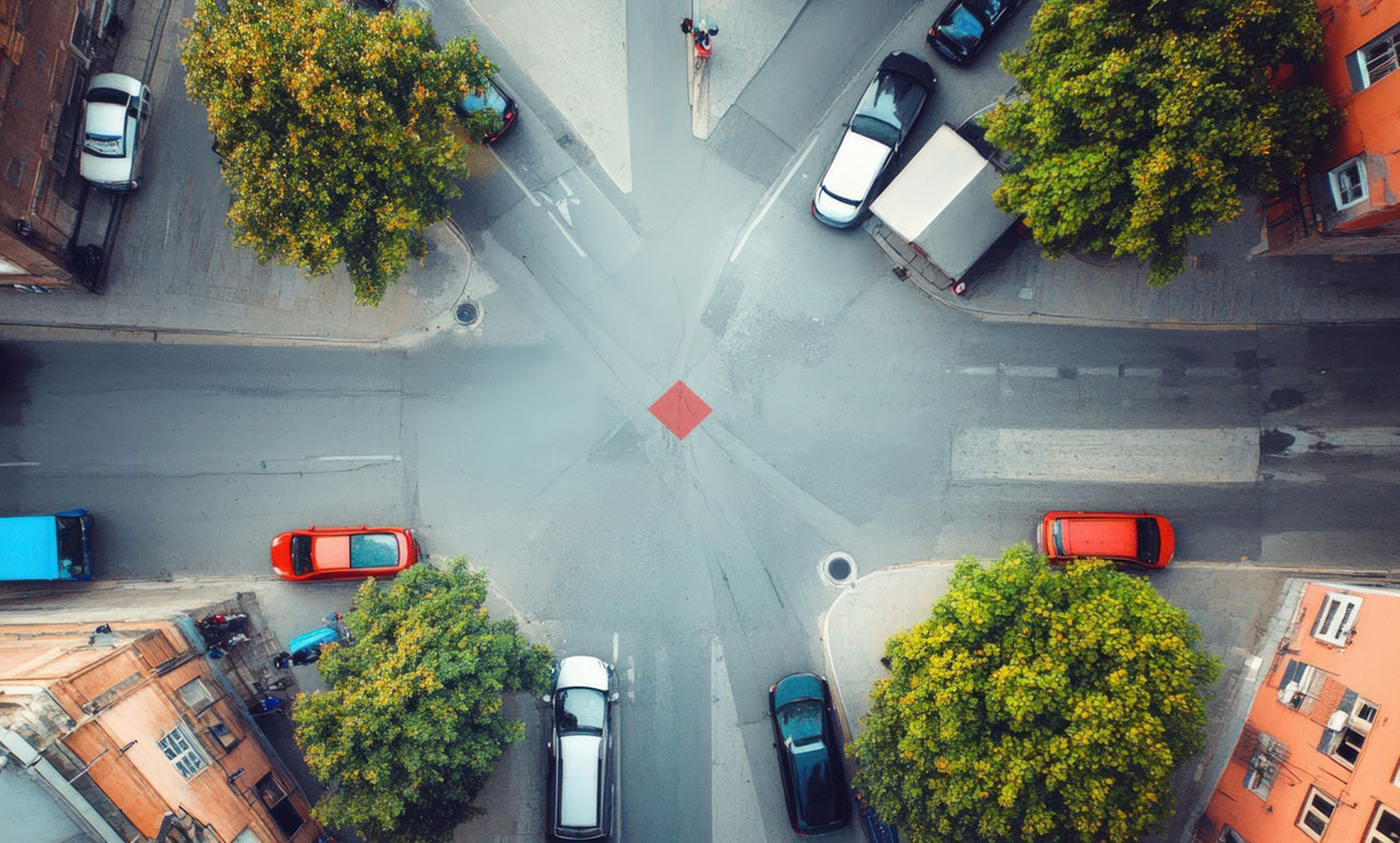 Aerial view of cars moving through a busy multi-lane city intersection, concept image representing the most dangerous intersections in Houston.