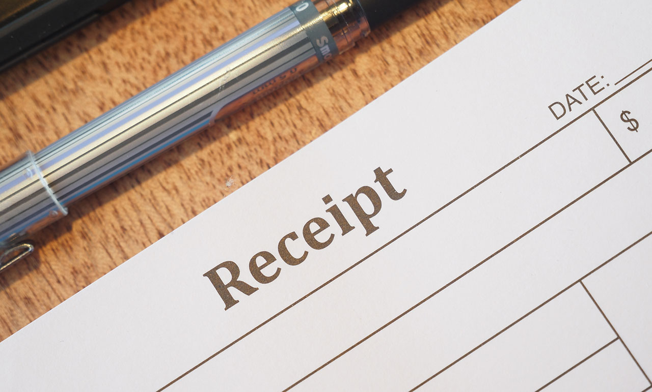 Receipt and pen on a table, representing bar tab and timestamp evidence used to prove Texas dram shop liability after a drunk driving crash