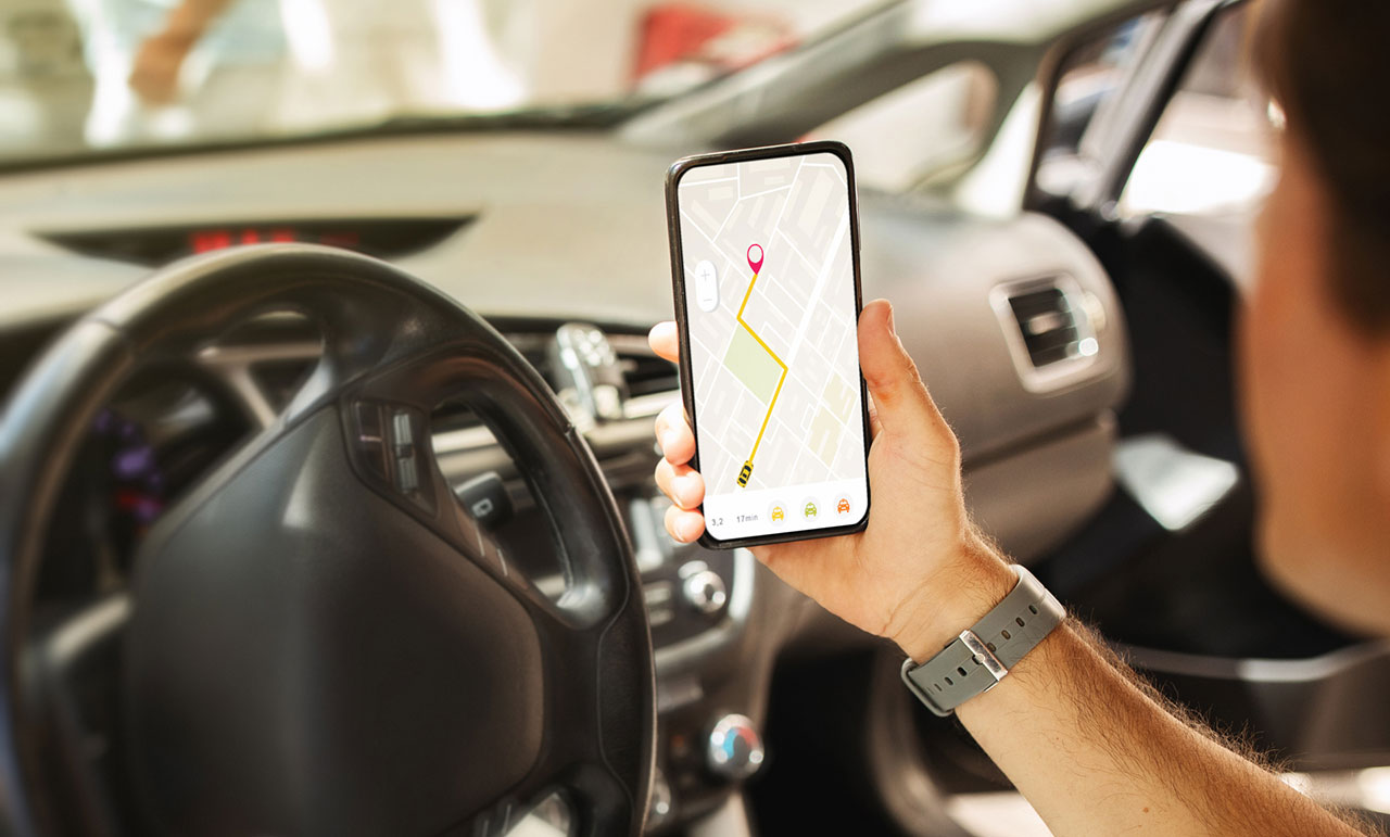 Smartphone held inside a car, concept image representing rideshare app status evidence and accessing the $1 million Uber or Lyft insurance policy