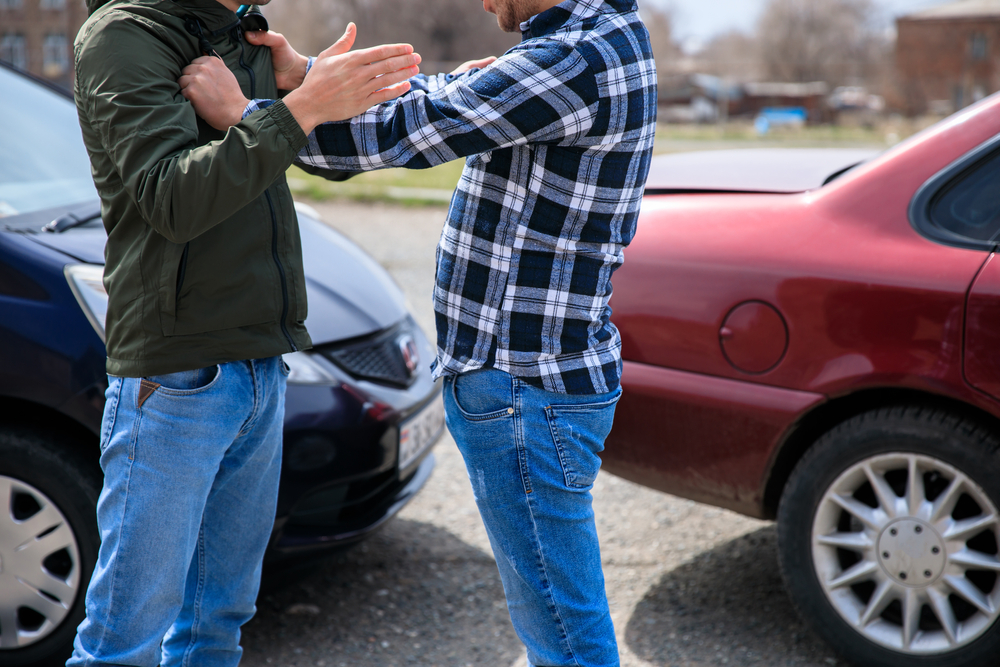 Two drivers arguing after a car accident while assigning blame for the crash