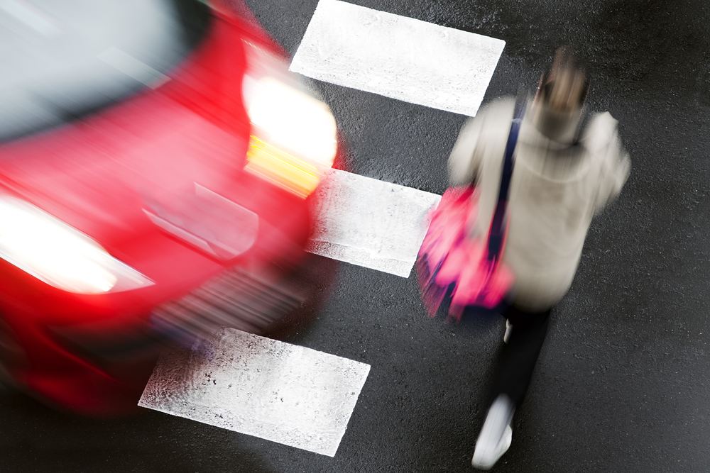 Car approaching a pedestrian in a marked crosswalk in Texas